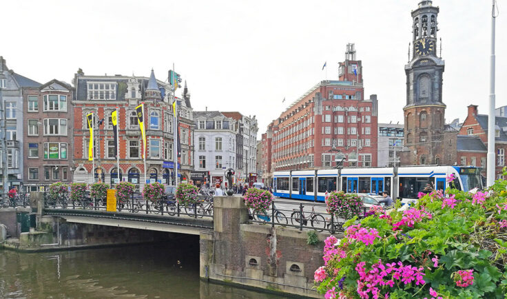 Sicht auf eine typische Grachtbrücke in Amsterdam. An der Brücke sind ADE Flaggen zu sehen.