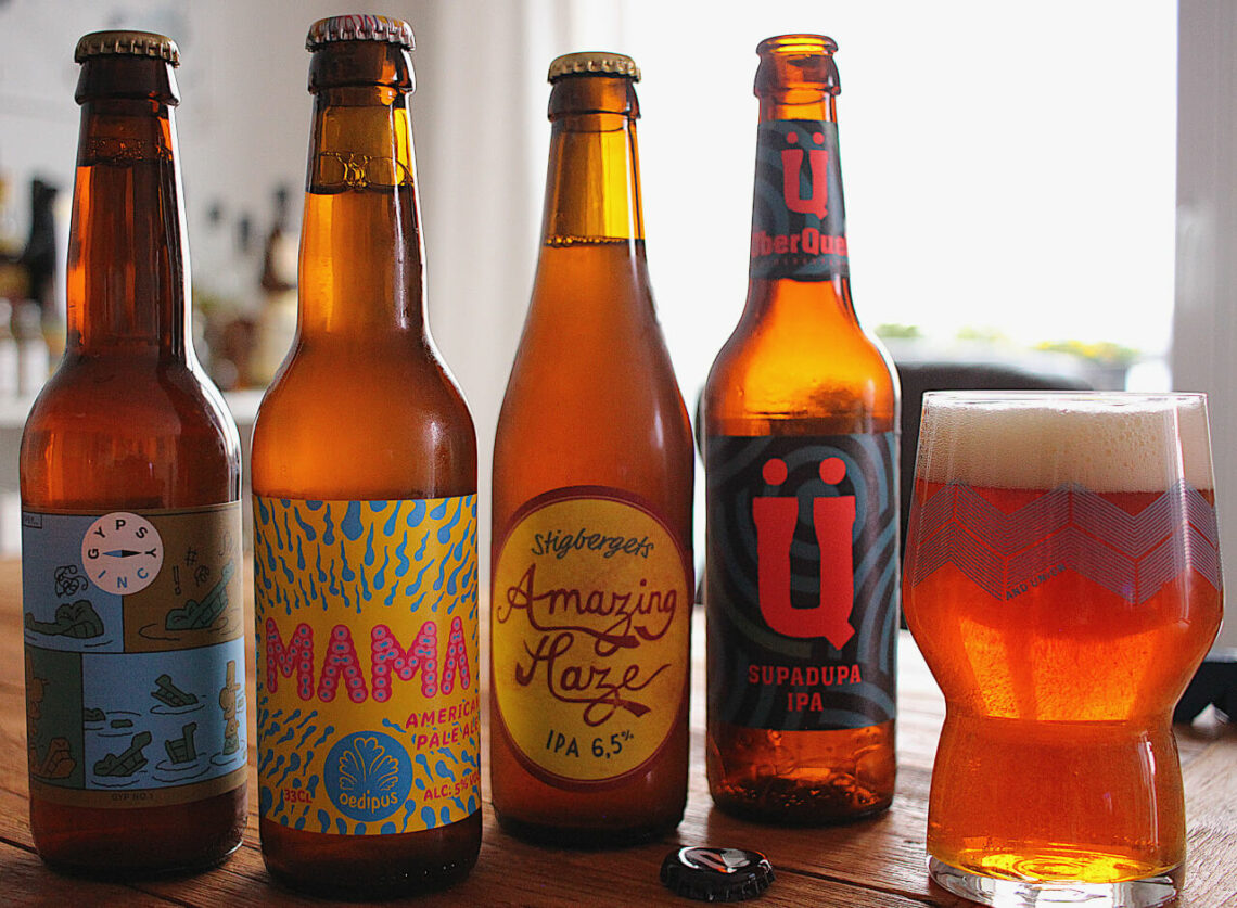 Die vier vorgestellten Biere stehen auf dem Tisch, daneben ein eingeschenktes Glas.